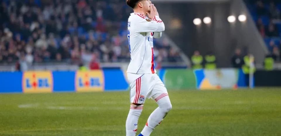 Игрок Олимпика Лион поднимает руки во время матча