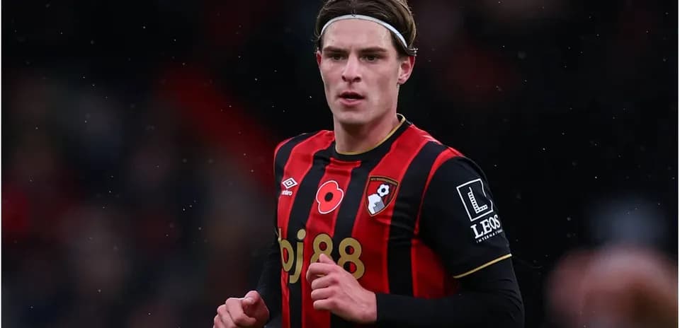 Игрок AFC Bournemouth в красно-черной форме на поле