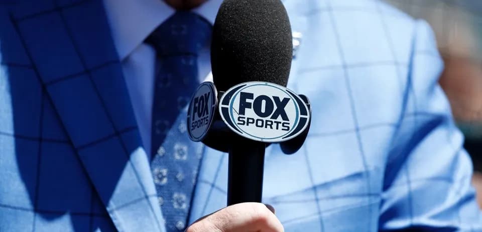 Микрофон FOX Sports в руке комментатора