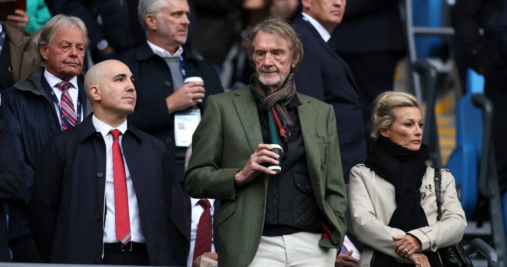 Four spectators watching a match in the stands
