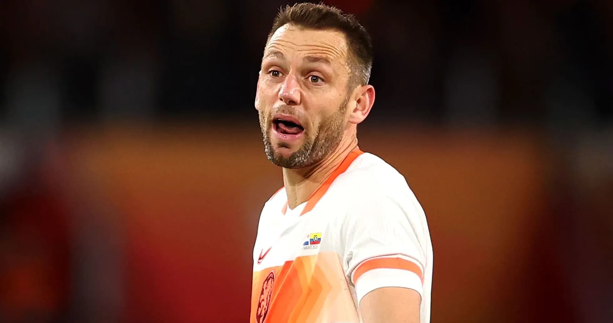 Игрок в белой футболке с оранжевыми деталями