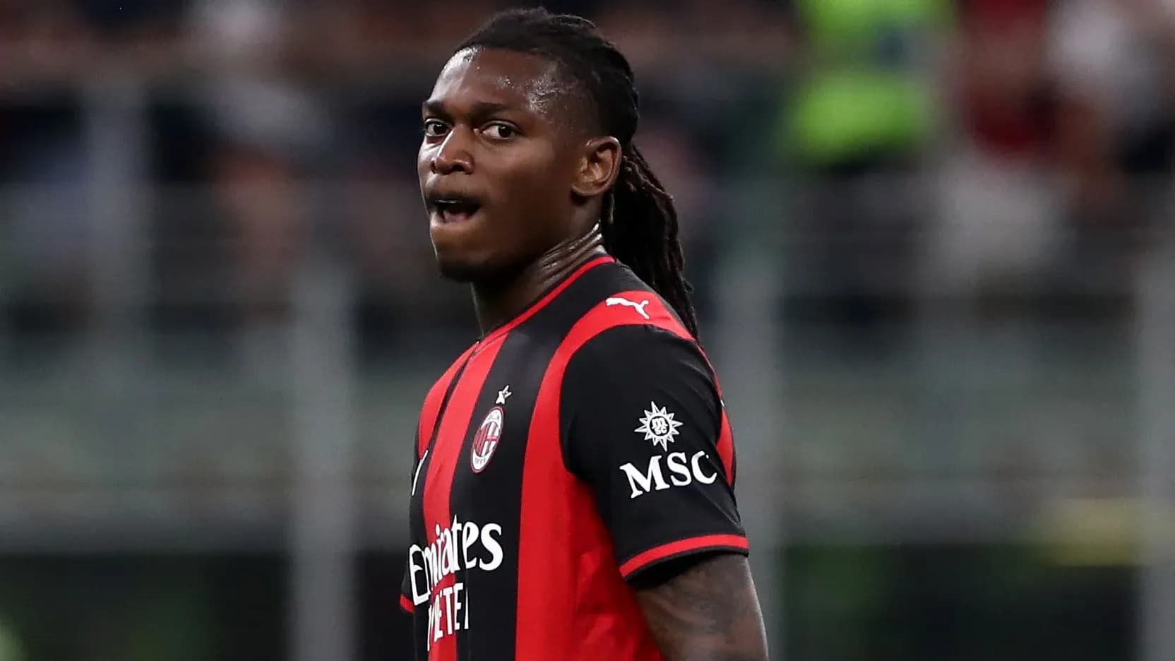 Игрок AC Milan в черно-красной форме на поле