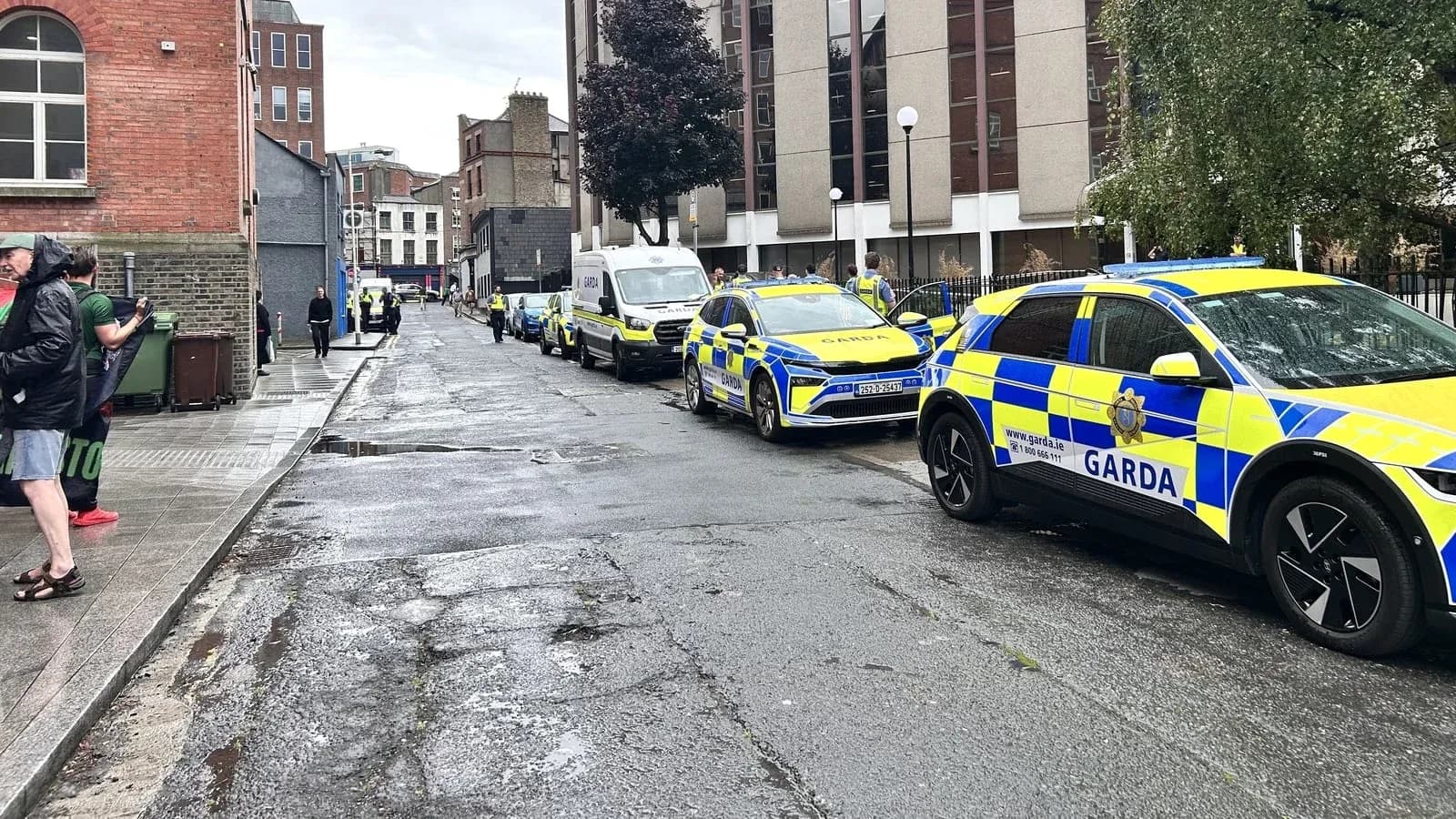Автомобили Garda на улице с людьми и зданиями Автомобили Garda на улице с людьми и зданиями
